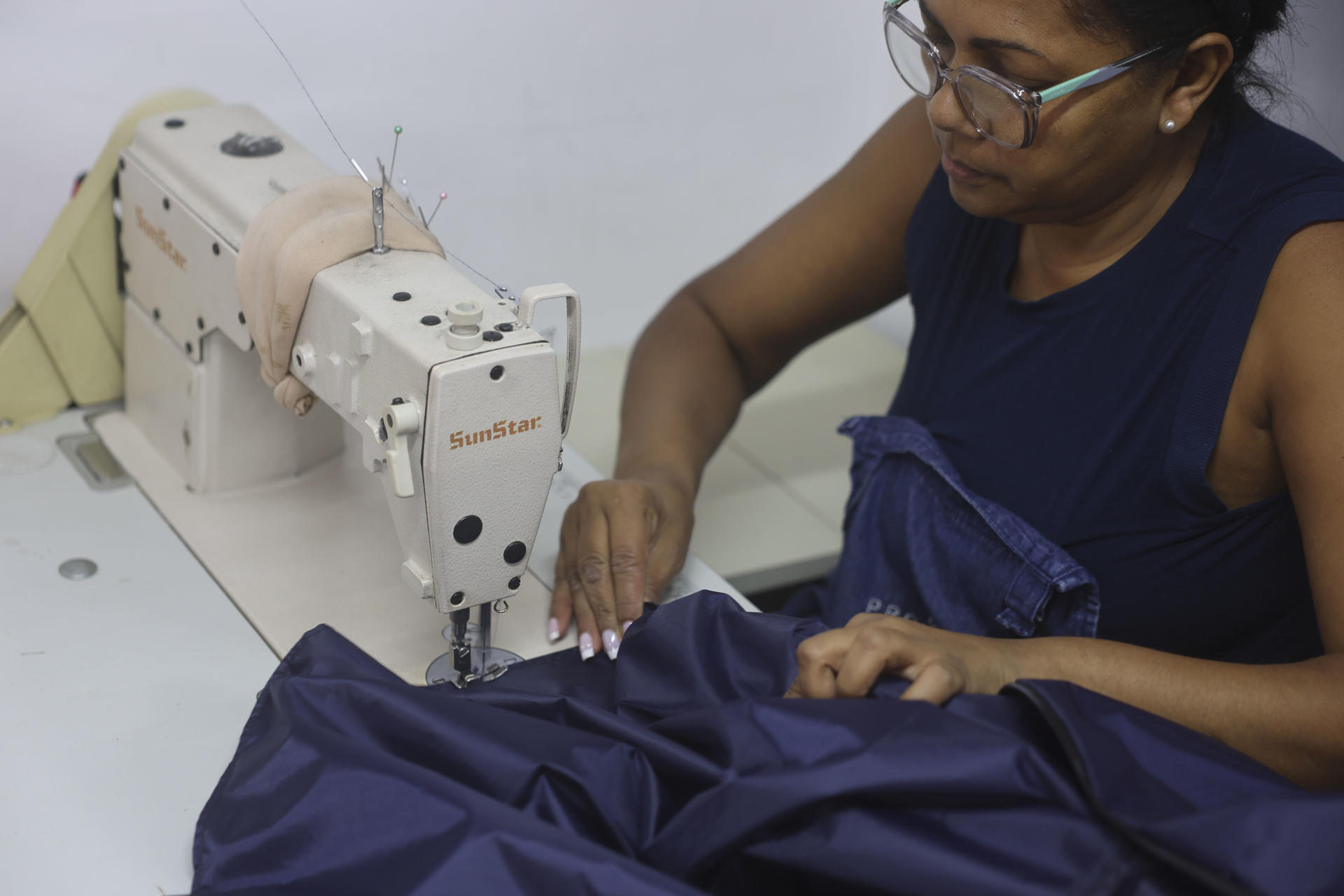 Una persona trabaja confeccionando bolsas mortuorias en el taller de la diseñadora Estefanía Sánchez este lunes, en Caracas (Venezuela). EFE/ Miguel Gutierrez