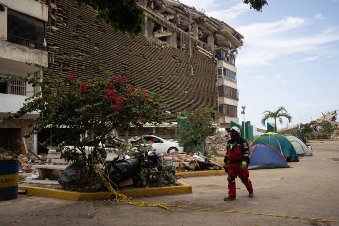 Una persona camina frente a edificios destruidos por terremotos en La Guaira (Venezuela). EFE/ Ronald Peña R
