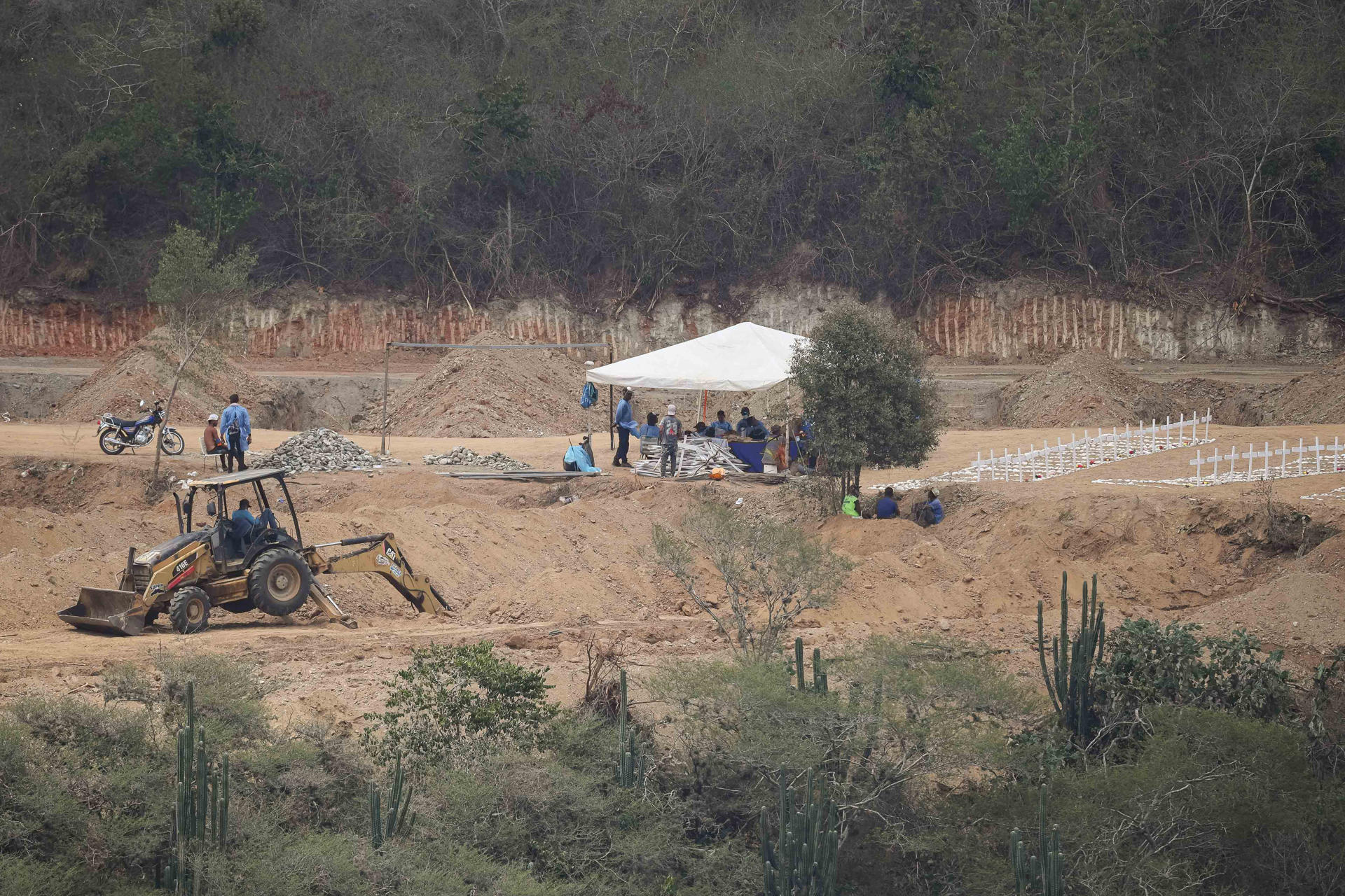 Fotografía que muestra a personas haciendo labores de excavación en el cementerio municipal La Esperanza este lunes, en Carayaca (Venezuela). EFE/ Ronald Peña R
