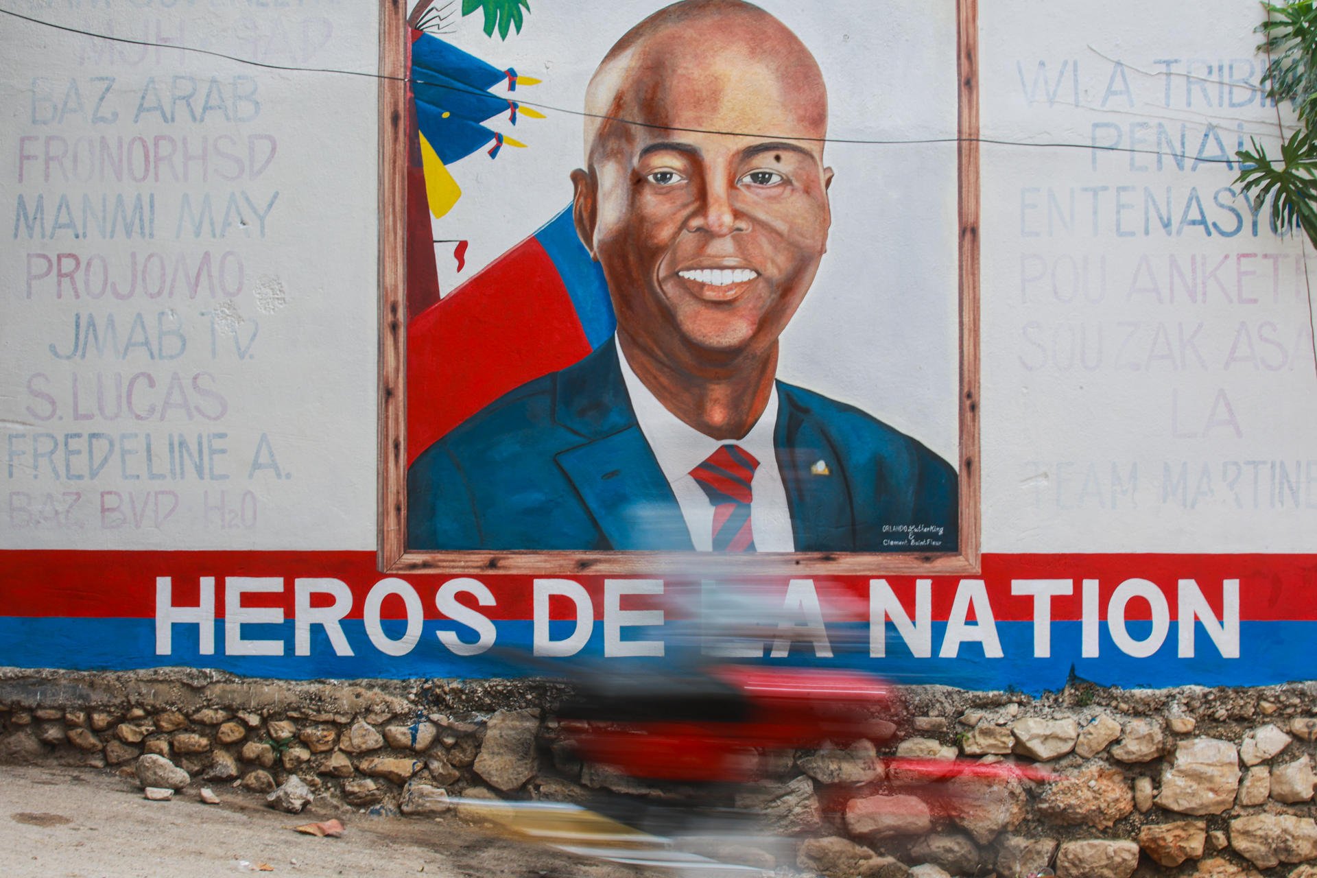 Una persona transita frente a un mural con la imagen del presidente haitiano, Jovenel Moïse, cinco años después de su asesinato la investigación judicial en Haití continúa sin avances sustanciales y sin que se haya iniciado un juicio, este lunes en Puerto Príncipe (Haití). EFE/ Mentor David Lorens
