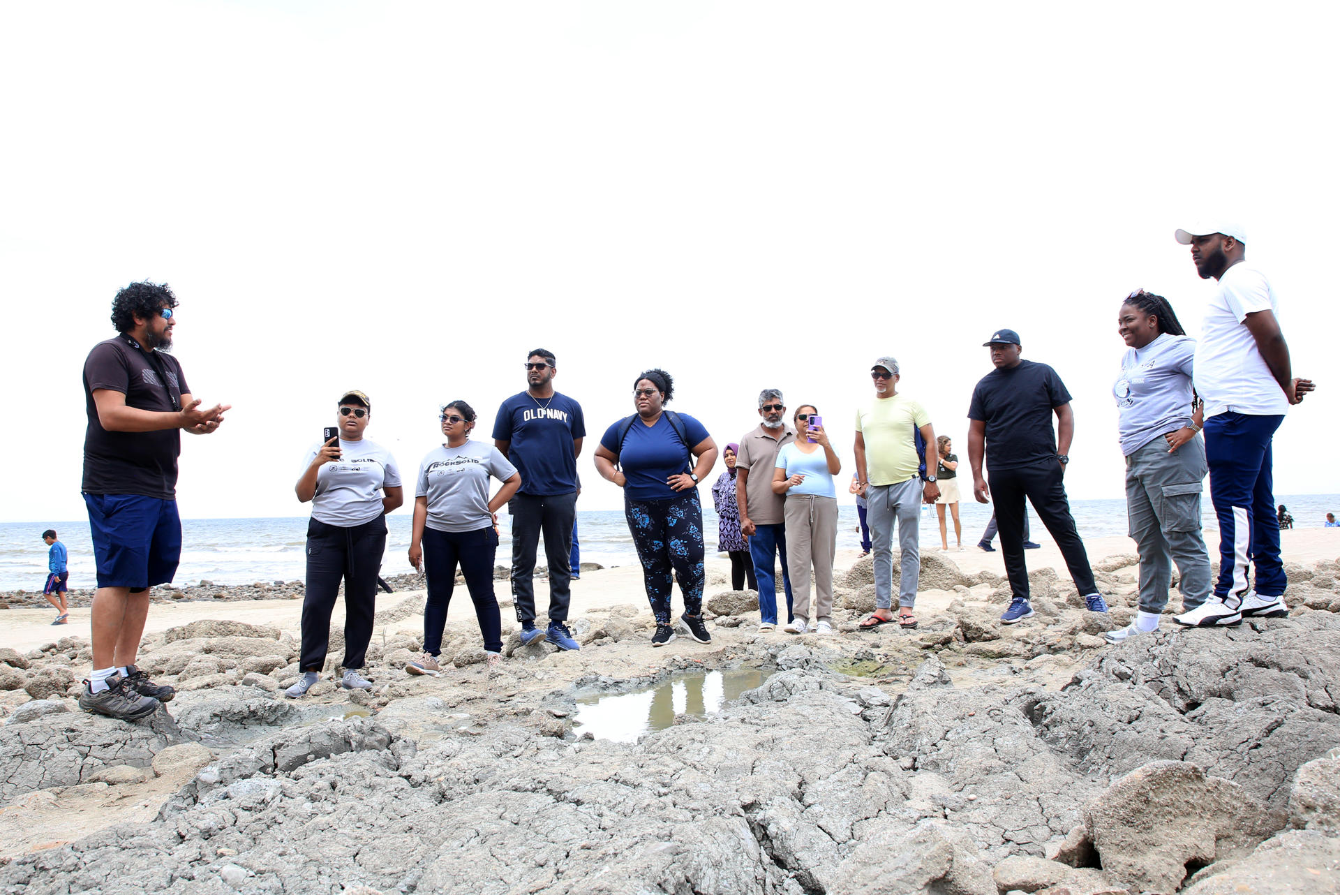 Fotografía del 5 de julio de 2026 del geocientífico Xavier Moonan (i) explicando a estudiantes y turistas las características geológicas de las rocas levantadas por los terremotos de Venezuela en la nueva línea costera de Galfa en Cedros (Trinidad y Tobago). EFE/Andrea de Silva