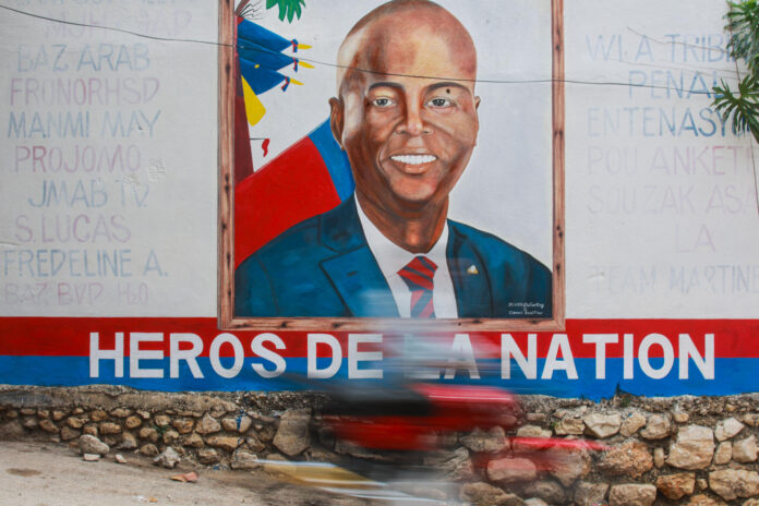 Una persona transita frente a un mural con la imagen del presidente haitiano, Jovenel Moïse, cinco años después de su asesinato la investigación judicial en Haití continúa sin avances sustanciales y sin que se haya iniciado un juicio, este lunes en Puerto Príncipe (Haití). EFE/ Mentor David Lorens
