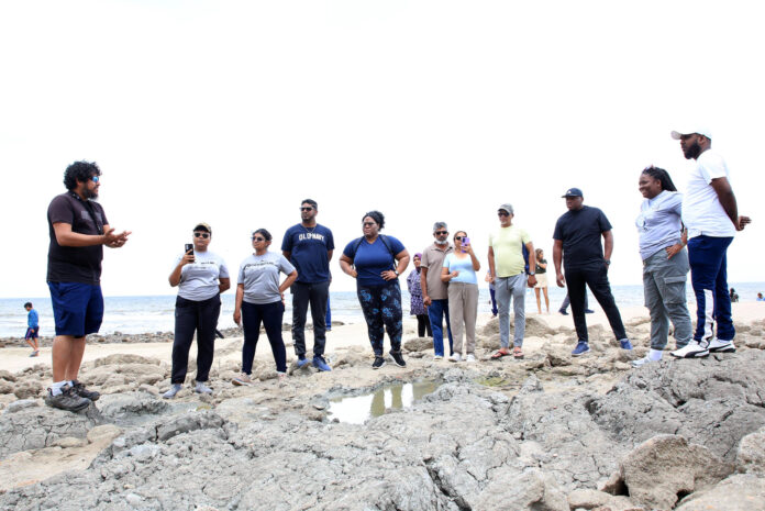 Fotografía del 5 de julio de 2026 del geocientífico Xavier Moonan (i) explicando a estudiantes y turistas las características geológicas de las rocas levantadas por los terremotos de Venezuela en la nueva línea costera de Galfa en Cedros (Trinidad y Tobago). EFE/Andrea de Silva
