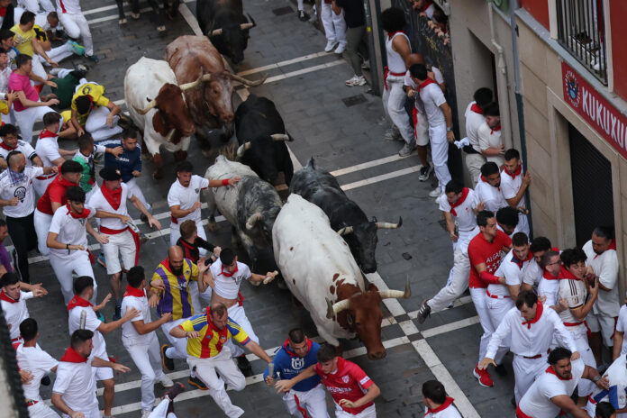 Los mozos corren delante de los toros de la ganadería gaditana de Cebada Gago en el segundo encierro de los Sanfermines 2026, este miércoles en Pamplona. EFE/ J.P. Urdiroz
