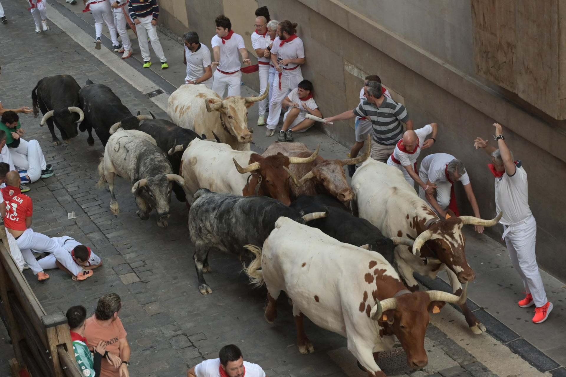 Mozos caen al paso de los toros de la ganadería gaditana de Cebada Gago, durante el segundo encierro de los Sanfermines 2026, este miércoles en Pamplona. EFE/ José Luis Larrión
