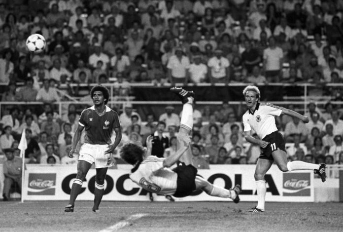 Fotografía de archivo del 8 de julio de 1982 en la que se observa al delantero alemán Klaus Fischer (c) al disparar a portería ante la mirada de su compañero Karl-Heinz Rummenigge (d) y el jugador francés Gerard Janvion, durante la semifinal del Mundial España'82 que enfrentó a las selecciones de Francia y República Federal de Alemania en el estadio Sanchez Pizjuán de Sevilla (España). EFE/ma/ARCHIVO
