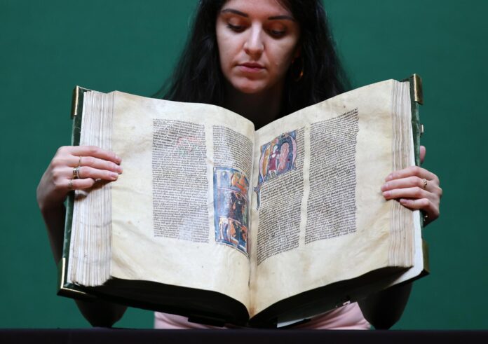 Un funcionario de la casa de subastas Christie’s con el Grial de Clermont-Tonnerre en Christie’s, Londres, Reino Unido, el 1 de julio de 2026. El Grial de Clermont-Tonnerre, un manuscrito de setecientos años que narra las leyendas del Rey Arturo, Merlín y el Santo Grial, se pondrá a la venta en Christie’s, Londres, el 8 de julio. (Reino Unido, Londres) EFE/EPA/ANDY RAIN
