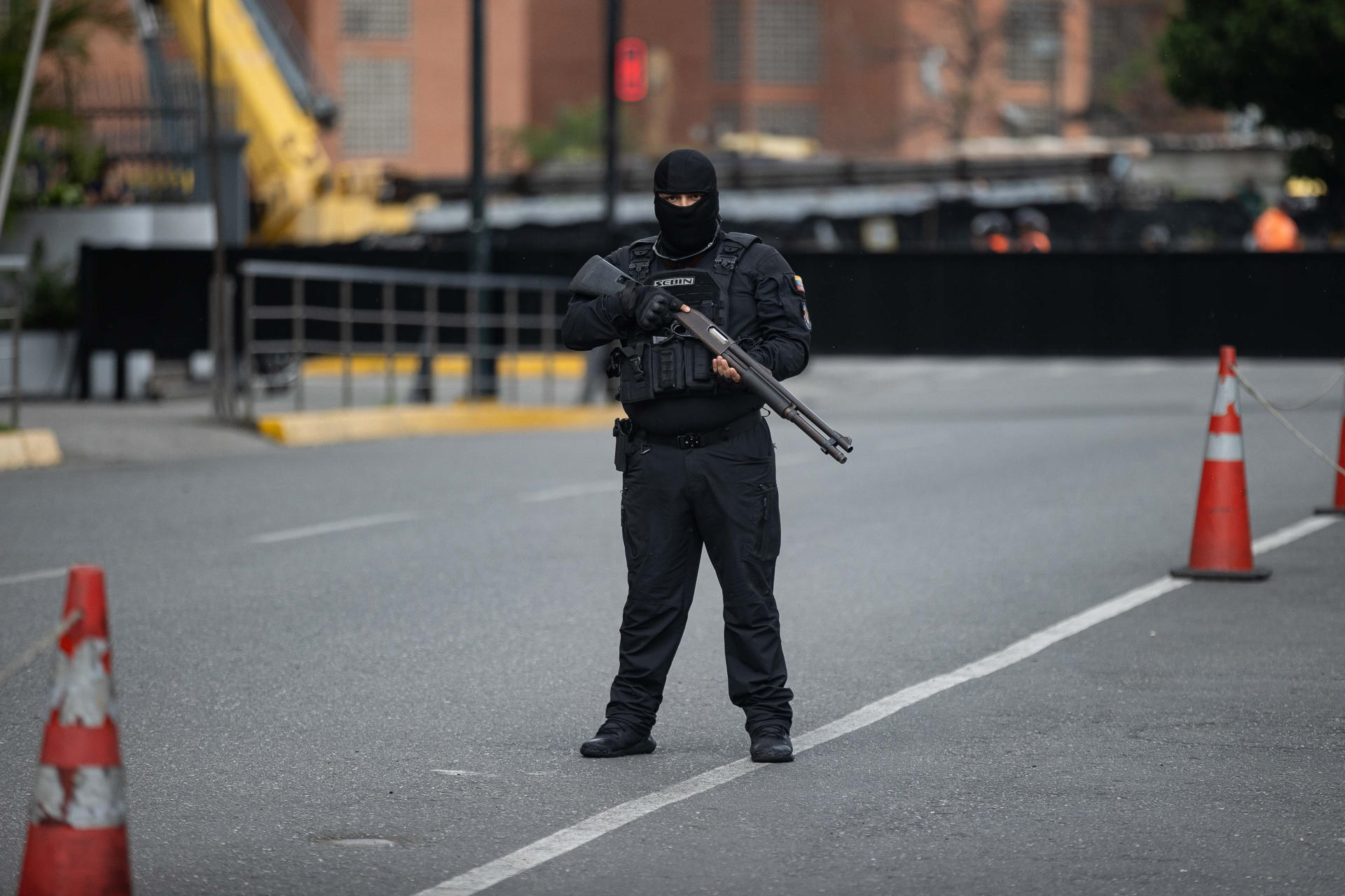 Un funcionario de Servicio Bolivariano de Inteligencia Nacional vigila una calle durante una manifestación de sindicalistas que exige la salida de la mandataria encargada de Venezuela, Delcy Rodríguez, y critica la respuesta del Gobierno tras los dos terremotos de hace dos semanas, en Caracas (Venezuela). EFE/ Ronald Peña R
