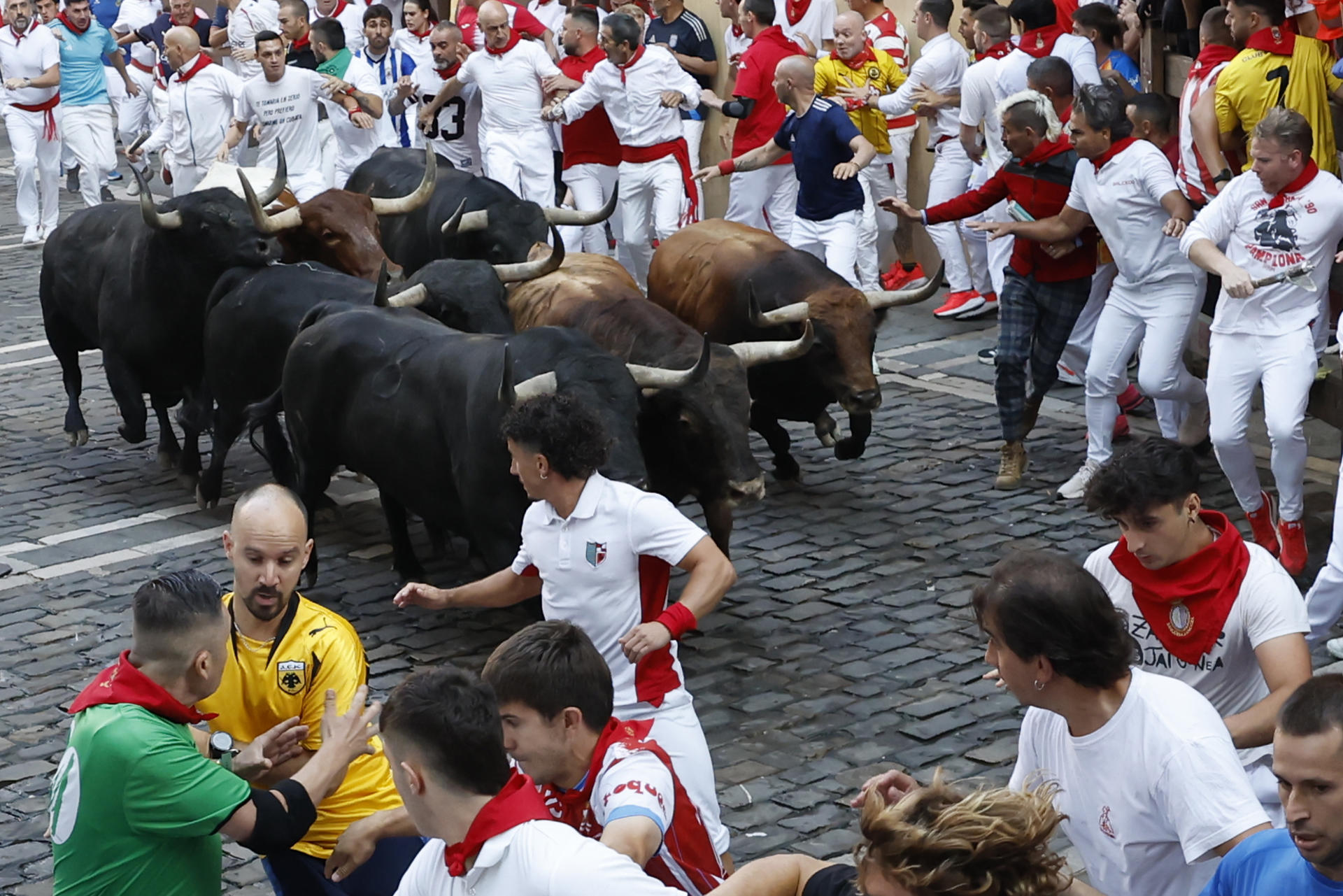 Varios mozos coren delante de los toros durante el tercer encierro de los Sanfermines, este jueves en Pamplona. EFE/Jesús Diges