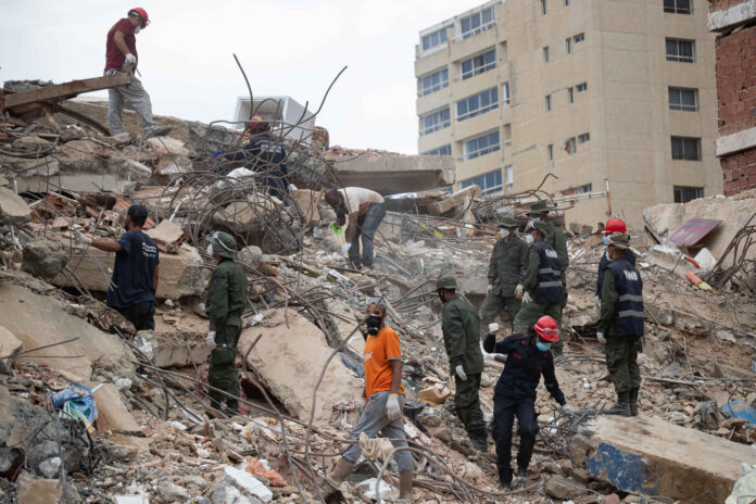 Voluntarios trabajan entre los escombros de edificios colapsados este lunes, en La Guaira (Venezuela). EFE/ Ronald Peña R
