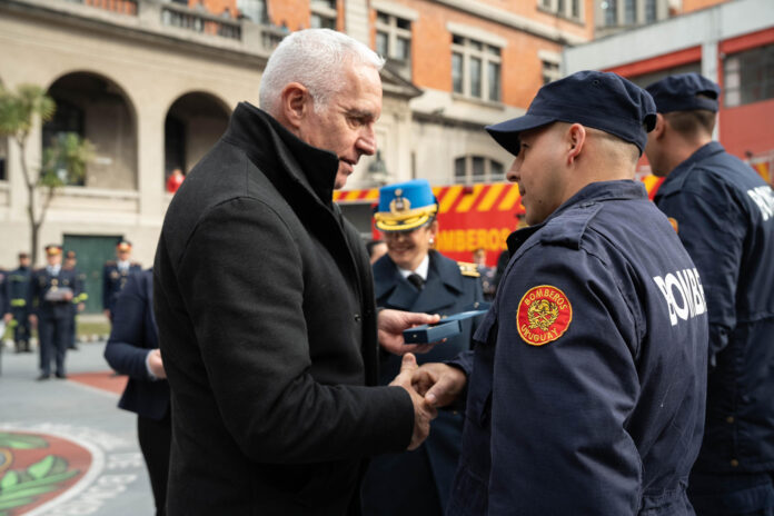 Fotografía cedida por la Presidencia de Chile que muestra al ministro de Interior de Uruguay, Carlos Negro (i), condecorando a un grupo de Bomberos que viajaron a Chile para ayudar a combatir los incendios forestales del pasado enero, este jueves en Montevideo (Uruguay). EFE/ Presidencia de Chile
