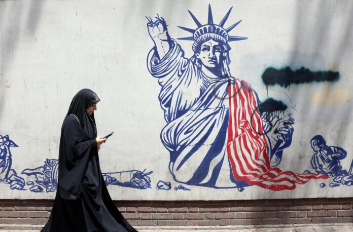 Una mujer pasa junto a un mural antiestadounidense cerca de la antigua embajada de EE. UU. en Teherán, Irán. Irán y EE. UU. intercambiaron disparos después de que el presidente estadounidense Trump declarara que el alto el fuego había terminado. EFE/ABEDIN TAHERKENAREH. RESTRICCIONES: Prohibido el acceso a medios de comunicación israelíes/canales de televisión en persa fuera de Irán/Prohibido el acceso a BBC Persian/VOA Persian/Manoto TV/Televisión Internacional de Irán. (Según lo dispuesto por la Dirección General de Medios de Comunicación Extranjeros de Irán).
