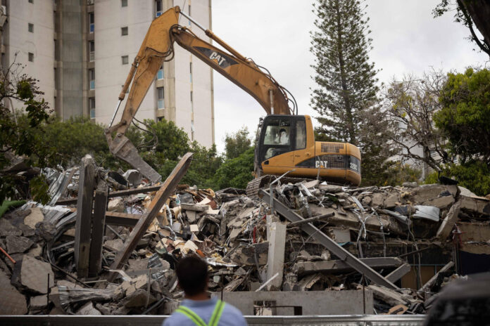 Fotografía de maquinaria pesada retirando este jueves escombros de un edificio afectado por el doble terremoto en Caracas (Venezuela). EFE/ Ronald Peña R
