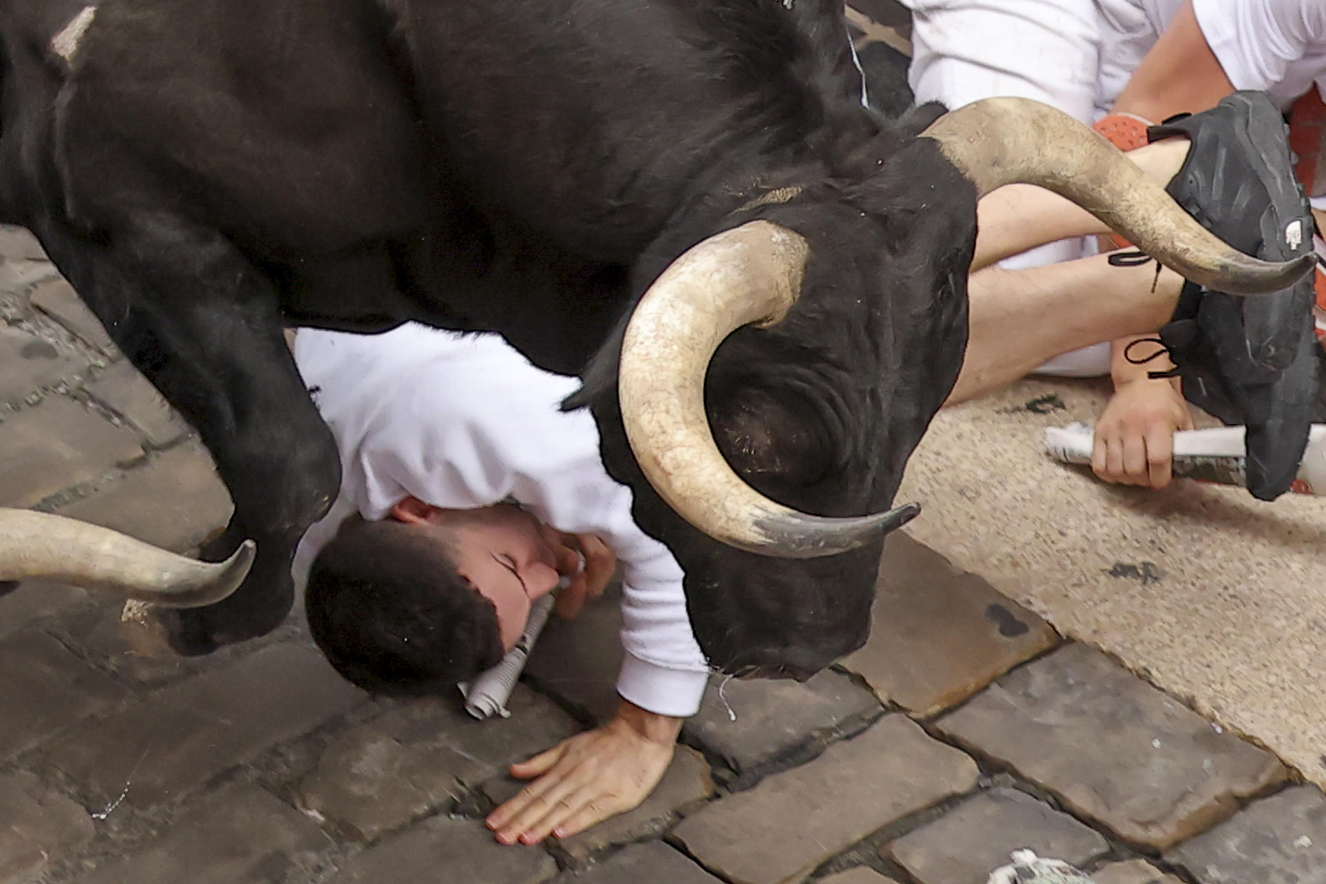 Un toro engancha a un mozo este viernes, durante el cuarto encierro de los Sanfermines 2026 en Pamplona. EFE/ J.P. Urdiroz
