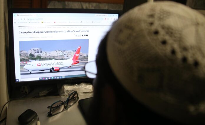 Imagen de archivo de un hombre consultando las noticias sobre la desaparición de un avión de carga de K2 Airways en Karachi, Pakistán, el 8 de julio de 2026. 
EFE/EPA/REHAN KHAN
