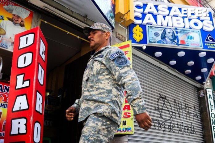 Una persona camina frente a una casa de cambio de divisas este jueves, en La Paz (Bolivia). La aplicación de un tipo de cambio flexible en Bolivia tras 15 años de un esquema fijo no resolverá por sí misma la falta de dólares que sufre desde 2023 el país advirtieron analistas. EFE/ Gabriel Márquez
