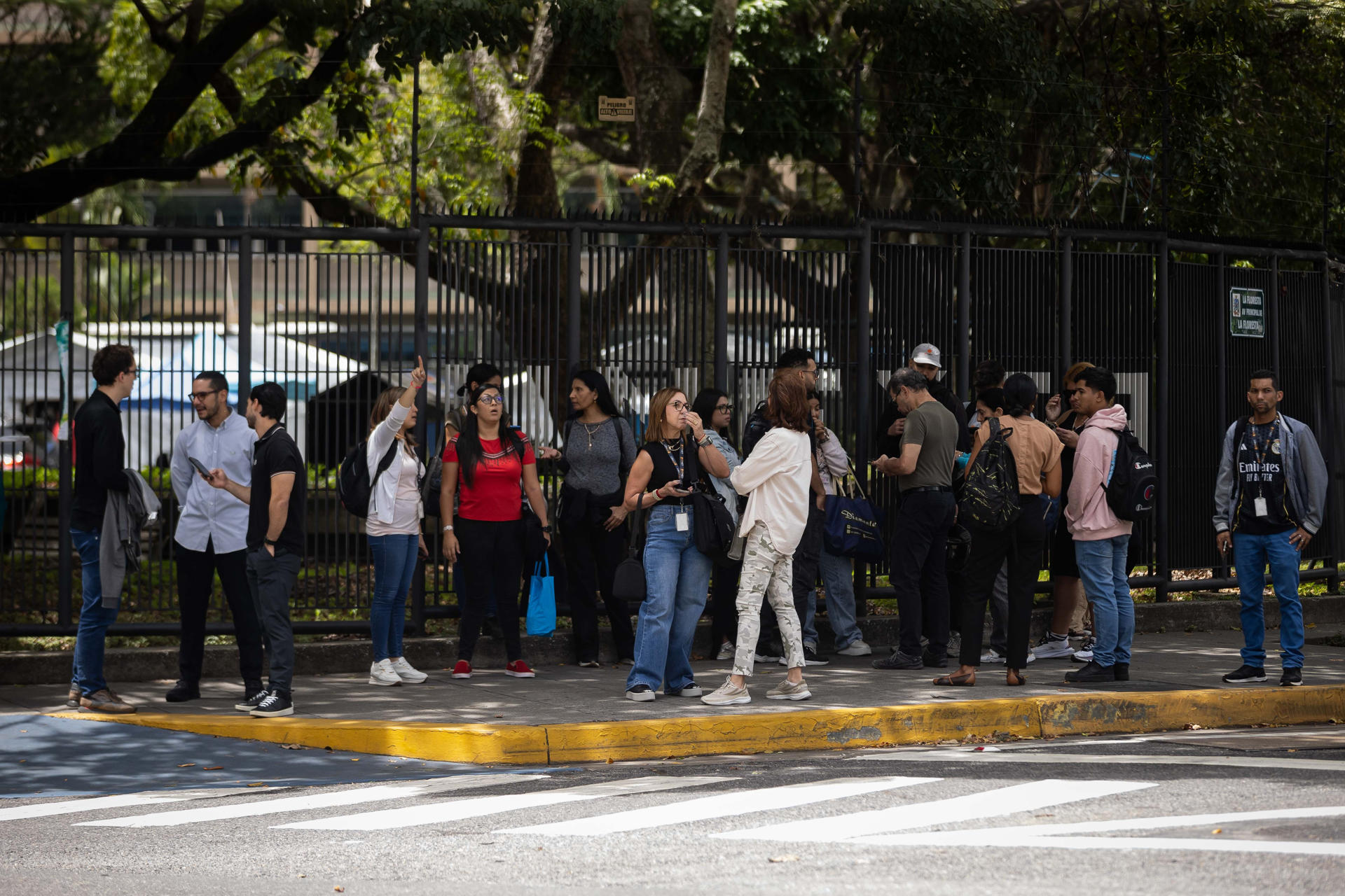 Personas esperan en una calle, luego de un temblor de magnitud 3,9, en Caracas (Venezuela). EFE/ Ronald Peña R
