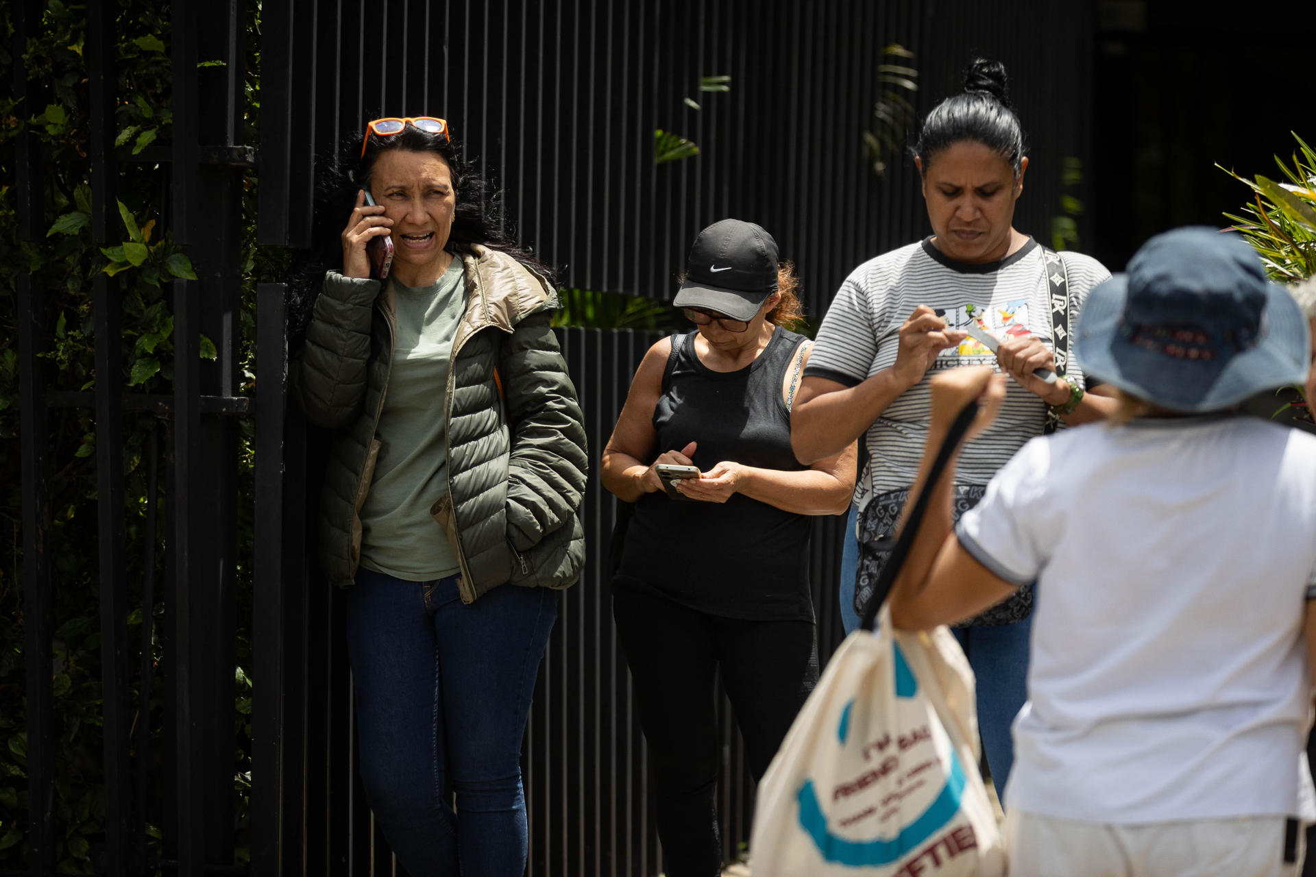 Personas esperan en una calle, luego de un temblor de magnitud 3,9, en Caracas (Venezuela). EFE/ Ronald Peña R
