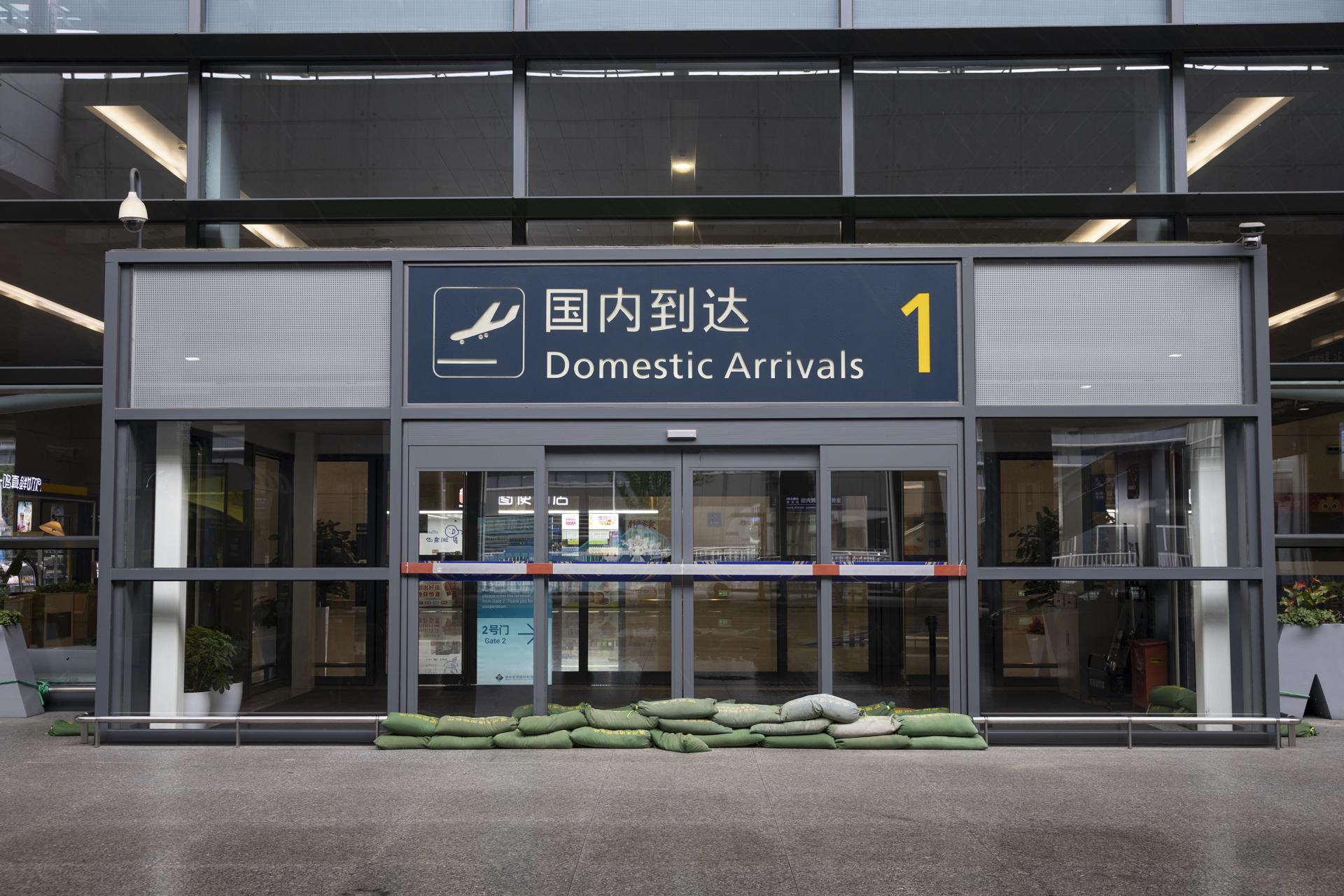 La entrada de la terminal de llegadas de vuelos nacionales del aeropuerto de Wenzhou protegido con sacos de arena ante el paso del tifón Bavi, en Wenzhou, en la provincia china de Zhejiang (sureste). EFE/EPA/ANDRES MARTINEZ CASARES
