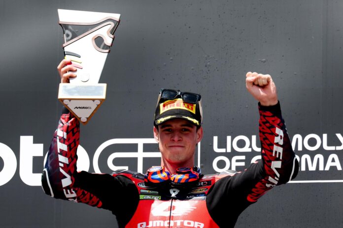 El piloto español de Moto2 Iván Ortolá, de QJMOTOR-Exocom-MSI, celebra en el podio tras ganar la carrera de Moto2 del Gran Premio de Alemania de motociclismo, en el circuito de carreras de Sachsenring en Hohenstein-Ernstthal (Alemania). EFE/EPA/FILIP SINGER
