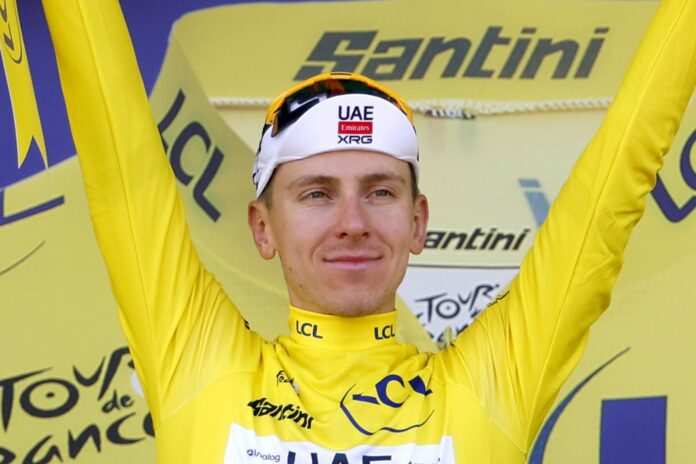 El ciclista esloveno Tadej Pogacar, del UAE Team Emirates XRG, celebra en el podio con el maillots amarillo de líder tras la novetna etapa con final en Ussel, Francia. EFE/EPA/GUILLAUME HORCAJUELO
