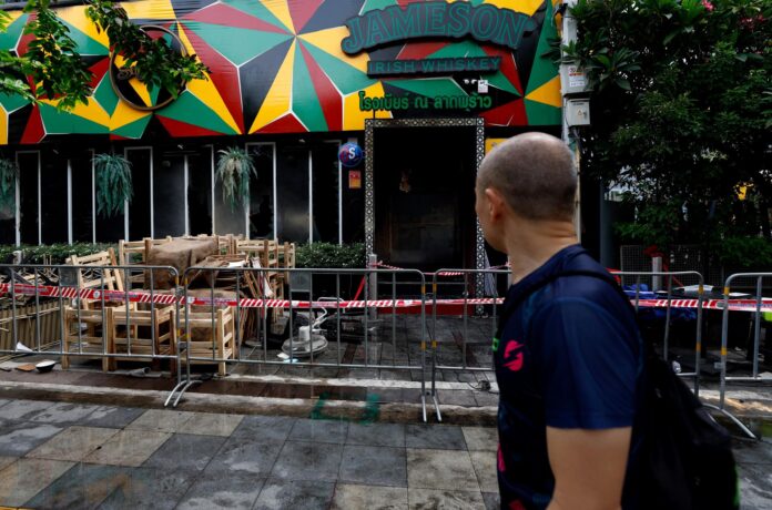 Un peatón pasa junto a un pub que fue escenario de un incendio fatal en Bangkok. Al menos 28 personas murieron después de que el fuego arrasara el local, según el primer ministro tailandés, Anutin Charnvirakul. EFE/EPA/RUNGROJ YONGRIT

