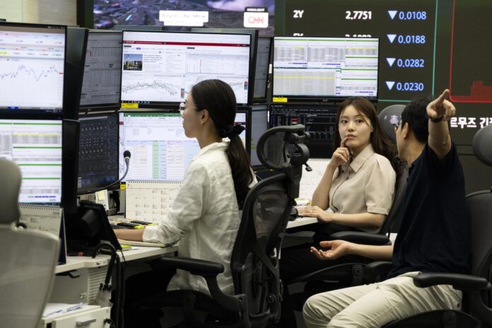 Operadores surcoreanos trabajan frente a monitores en el Banco Hana en Seúl, este lunes. El índice KOSPI cayó 669,01 puntos, un 8,95%, para cerrar en 6.806,93 puntos. EFE/EPA/JEON HEON-KYUN
