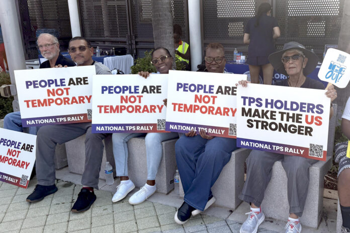 Haitianos sostienen carteles durante una manifestación que pide el Estatus de Protección Temporal frente al Centro Cultural de la Pequeña Haití en Miami, Florida (EE.UU). EFE/Pablo Urbón
