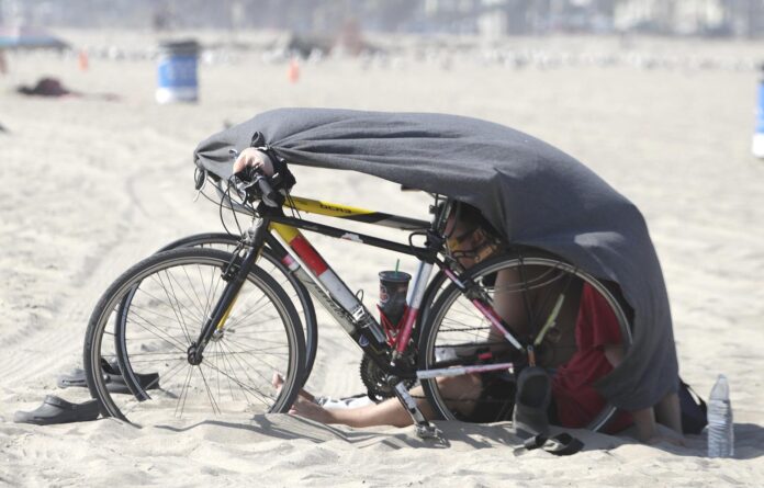 Un bañista se protege del sol en medio de una ola de calor en la playa Venice en Los Ángeles (CA, EE.UU.). Fotografía de archivo. EFE/MIKE NELSON
