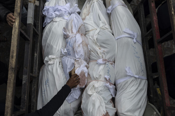 Imagen de archivo de un niño entre los cadáveres de varias víctimas de una ofensiva israelí en la localidad de Beit Lahia, en el extremo norte de la Franja de Gaza.  EFE/ Ahmad Awad
