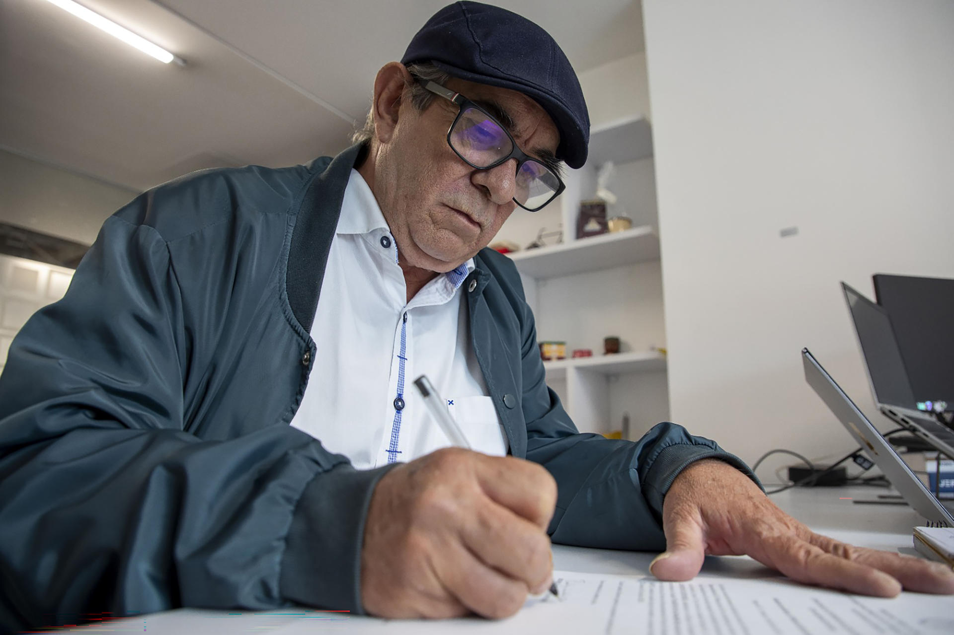 Fotografía cedida por Jurisdicción Especial para la Paz (JEP) que muestra a Rodrigo Londoño, conocido como Timochenko, último jefe de las FARC, firmando un documento en las instalaciones de la JEP este martes en Bogotá (Colombia). EFE/ Jurisdicción Especial para la Paz
