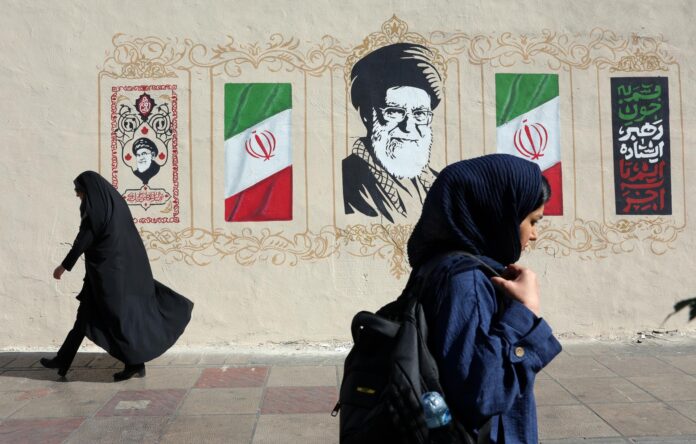 Mujeres iraníes caminan junto a un mural del difunto Líder Supremo iraní, el ayatolá Ali Jamenei, en una calle de Teherán, Irán, este miércoles. EFE/EPA/ABEDIN TAHERKENAREH RESTRICCIONES: Prohibido el acceso a medios de comunicación israelíes/canales de televisión en persa fuera de Irán/Estrictamente prohibido el acceso a BBC Persian/VOA Persian/Manoto TV/Televisión Internacional de Irán. (Según lo dispuesto por la Dirección General de Medios de Comunicación Extranjeros de Irán)
