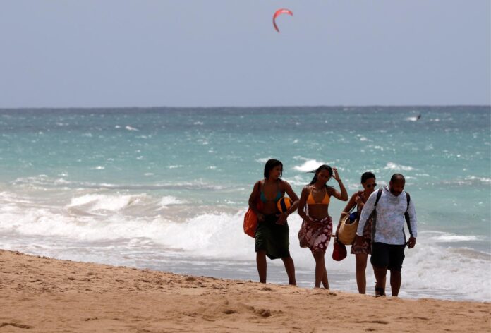 Unas personas caminan en grupo en la playa de San Juan, Puerto Rico. Fotografía de archivo. EFE/Thais Llorca
