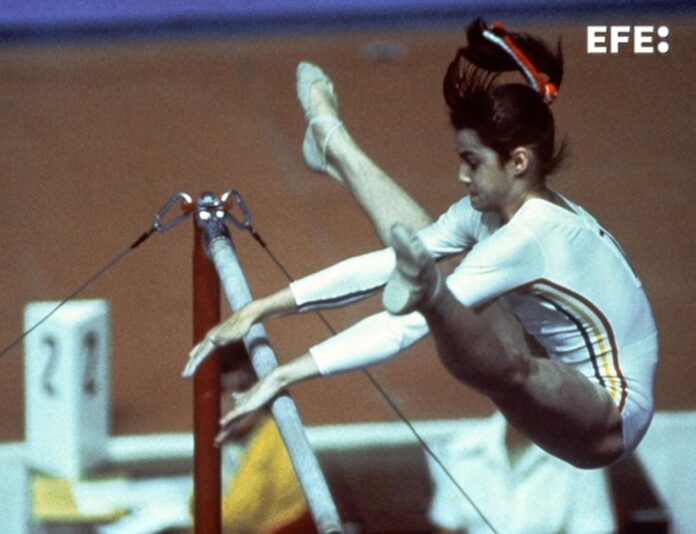 Fotografía de archivo (18/07/1976) de la gimnasta rumana Nadia Comaneci, durante su actuación en barras paralelas asimétricas en los Juegos Olímpicos de Montreal de 1976, donde obtuvo una puntuación máxima de 10 puntos, nota que se concedió por primera vez en gimnasia en unos Juegos Olímpicos, y que le valieron una medalla de oro. Medio siglo después de su inauguración, los Juegos Olímpicos de Montreal siguen siendo una de las citas más contradictorias de la historia olímpica: la perfección de Nadia Comaneci convivió con el boicot contra el apartheid, la crisis de Taiwán y una factura que Canadá tardó tres décadas en cerrar. EFE
