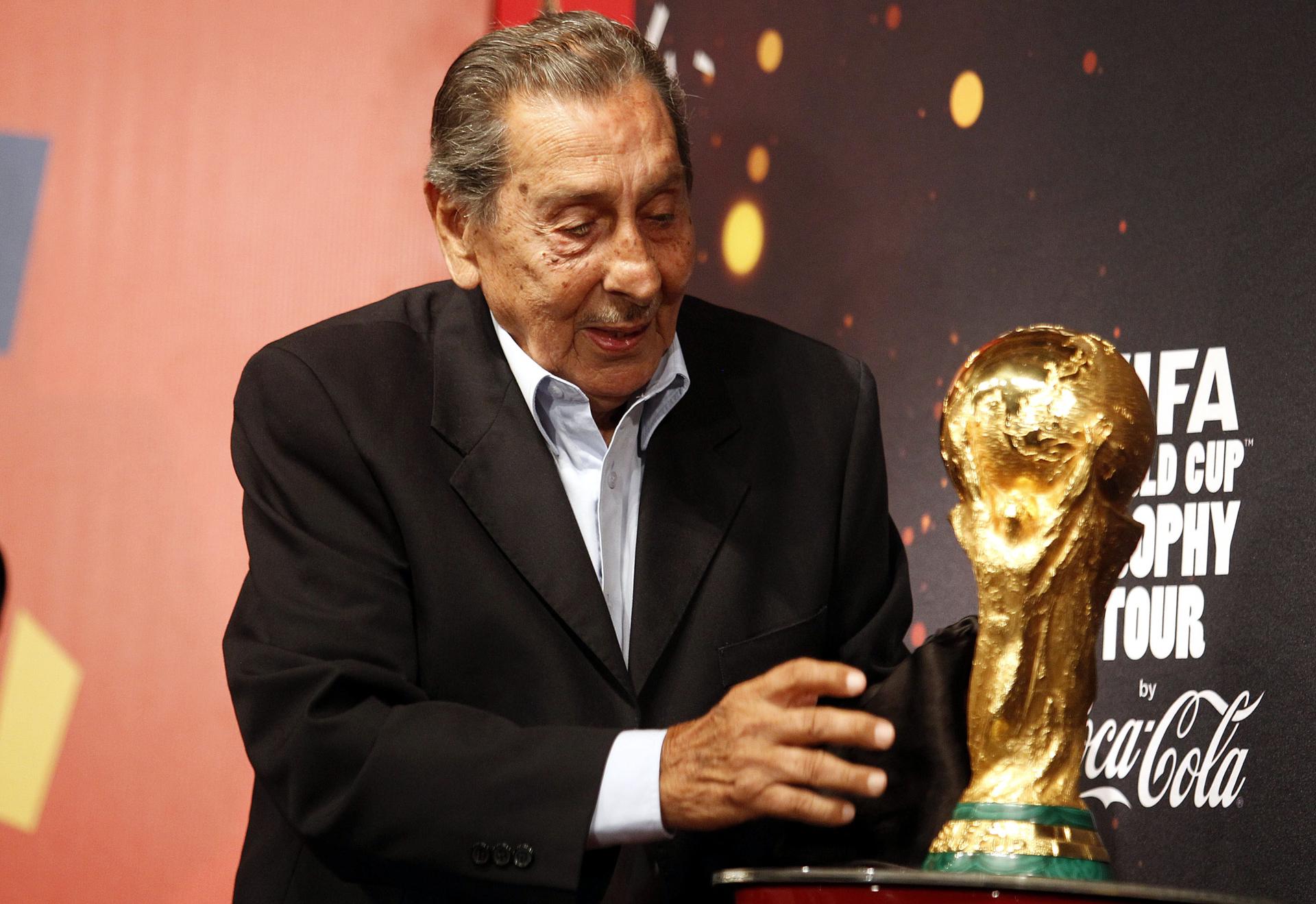 Fotografía de archivo del 16 de enero de 2014, en la que puede verse al exfutbolista uruguayo Alcides Ghiggia, último superviviente del maracanazo de 1950, con la Copa del Mundo. EFE/Iván Franco