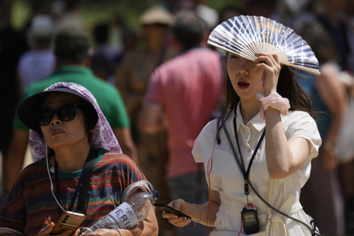 Una turista se resguarda del sol en la Sagrada Familia de Barcelona. EFE/Alejandro García

