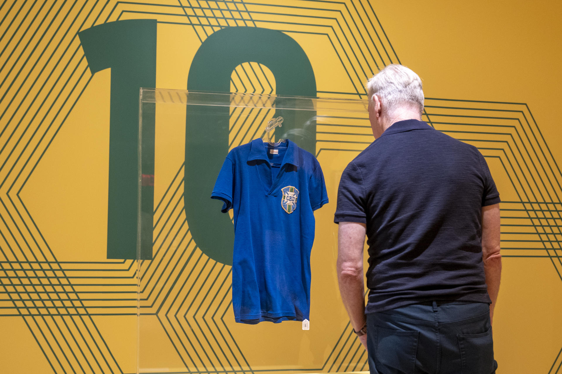 Una persona observa la camiseta que Pelé vistió en la final del Mundial de Suecia 1958, una pieza histórica del fútbol mundial, la cual se vendió este jueves en Sotheby's por 4,9 millones de dólares, convirtiéndose en el objeto más caro relacionado con su carrera deportiva, en Nueva York (Estados Unidos). EFE/ Angel Colmenares
