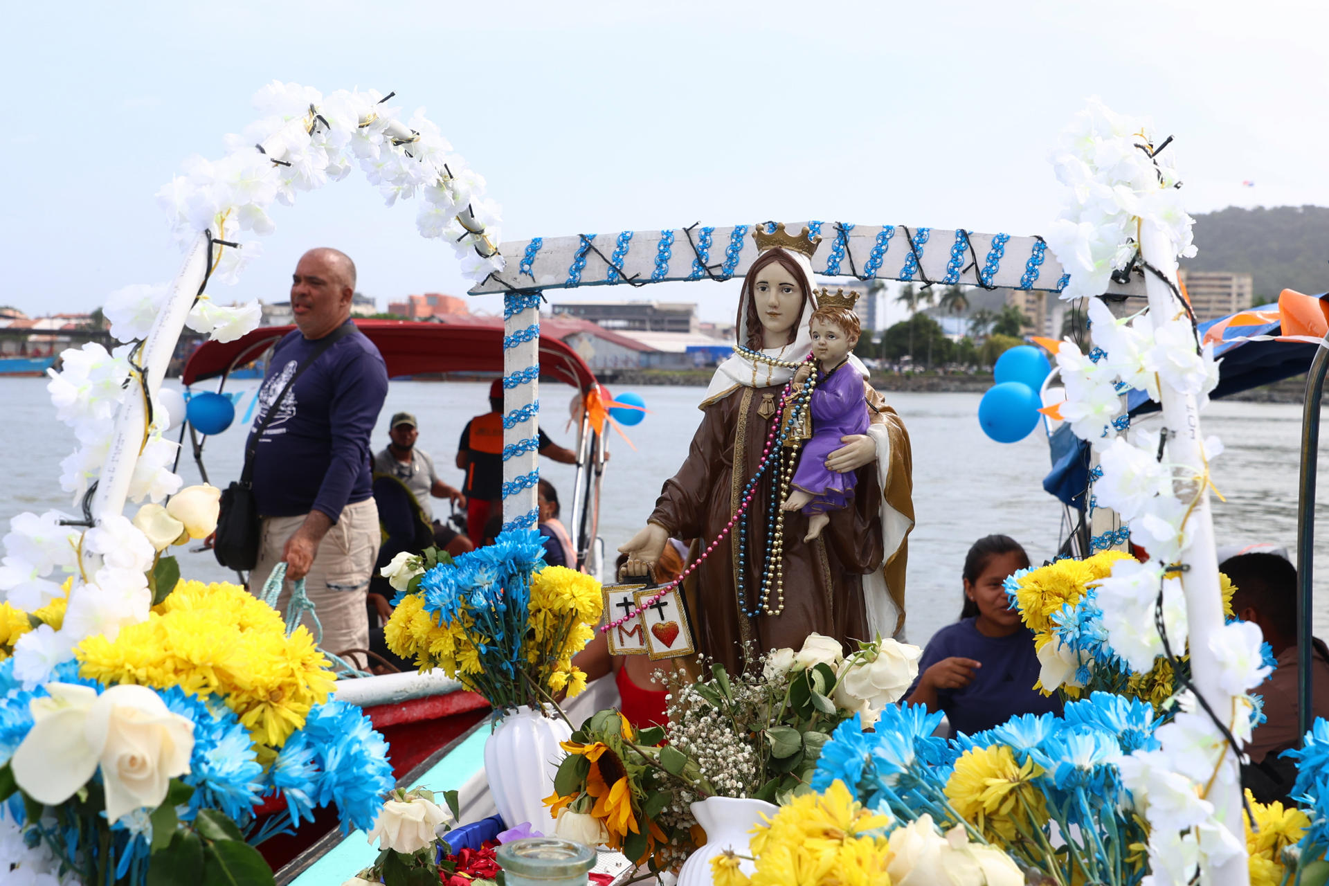 Personas navegan junto a una figura de la Virgen del Carmen adornada de flores azules y amarillas en su día este 16 de julio de 2026, en la bahía de Ciudad de Panamá (Panamá). EFE/ Carlos Lemos
