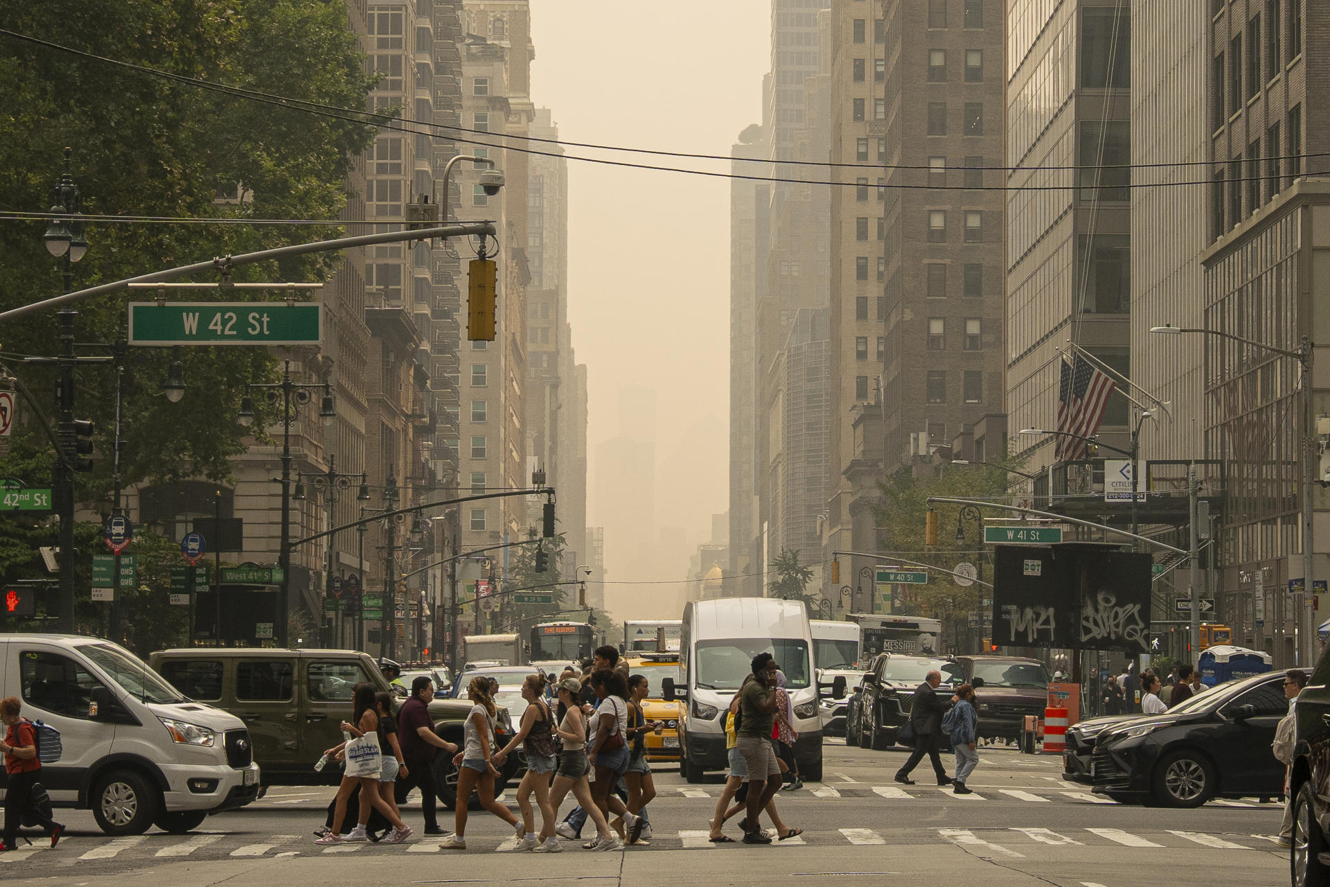 Personas caminan por una calle en Nueva York. Una densa capa de humo procedente de los incendios forestales en Canadá ha provocado una caída drástica en la calidad del aire en gran parte de Estados Unidos, desde los Grandes Lagos hasta la ciudad de Nueva York. EFE/Ángel Colmenares