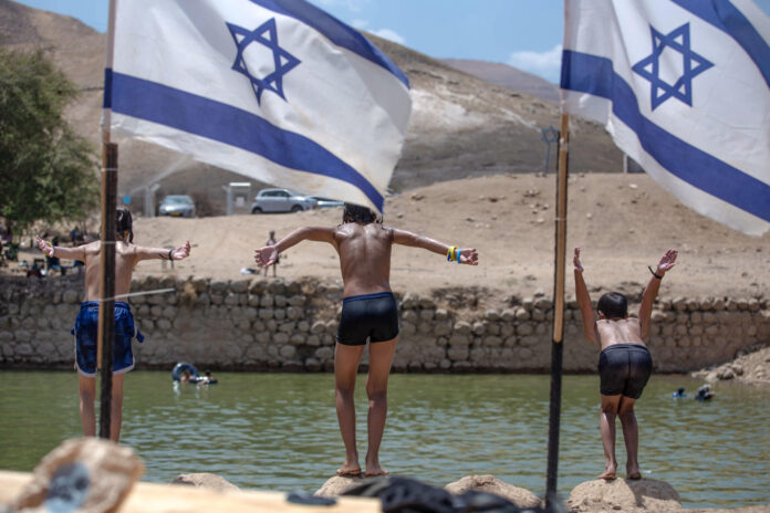 Colonos y soldados israelíes se bañan en una poza que asocian al Rey Herodes cerca del asentamiento ilegal de Petzael, situado en territorio palestino -en el Valle del Jordán en Cisjordania ocupada-. EFE/Patricia Martinez
