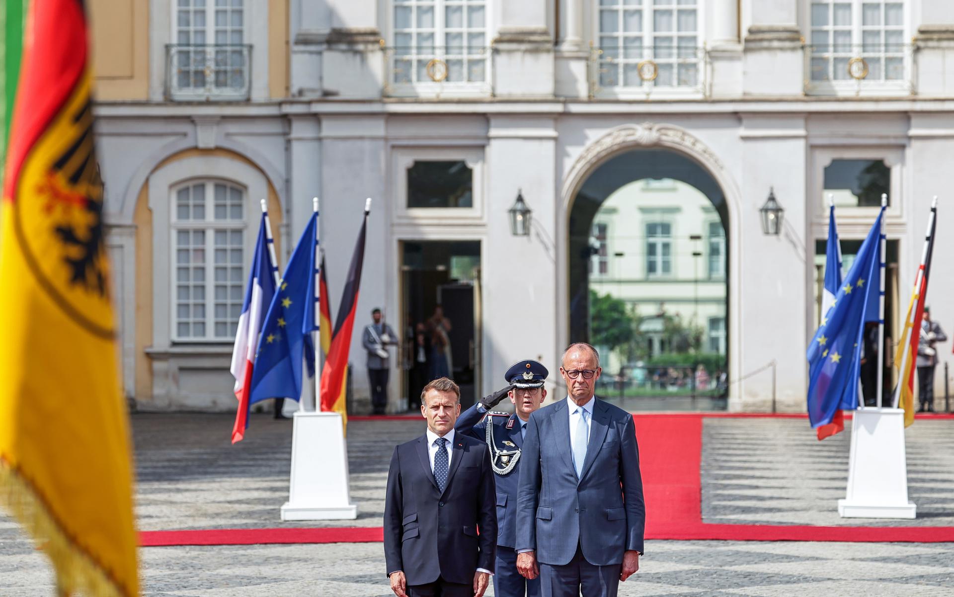 El canciller alemán, Friedrich Merz (d), y el presidente francés, Emmanuel Macron (i), pasan revista a la guardia de honor antes del 26 Consejo de Ministros franco-alemán, celebrado en Bruhl (Alemania) y centrado en estrategias para fortalecer la competitividad y la soberanía europea. EFE/EPA/FRIEDEMANN VOGEL
