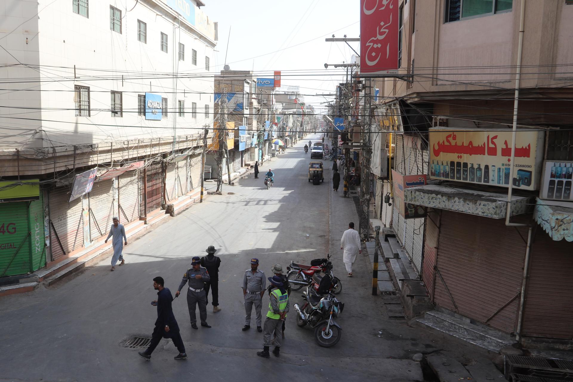 Un grupo de personas en una calle donde los comercios permanecen cerrados durante una huelga general en Quetta, Pakistán, este viernes. EFE/EPA/FAYYAZ AHMAD
