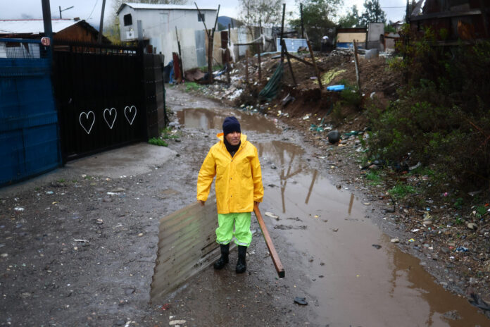 Una persona reacciona en un campamento que presenta riesgo de inundación por el temporal en la rivera del río Mapocho en Talagante (Chile). EFE/ Javier Torres Lantadilla
