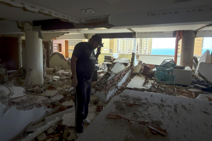 Una persona habla por teléfono en una edificación destruida por los terremotos del 24 de junio, este jueves en Catia La Mar (Venezuela). EFE/ Miguel Gutiérrez
