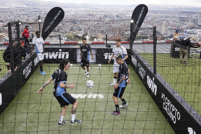Integrantes de los equipos: la banda de Alex (blanco) y la bandera de Pablo (negro) juegan fútbol en el helipuerto de la Torre Colpatria en Bogotá (Colombia). EFE/ Carlos Ortega
