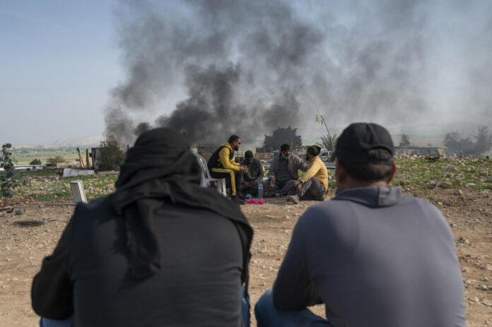 Imagen de archivo en la que un grupo de palestinos beduinos toma té mientras concluye el desalojo de sus vivienda en la localidad cisjordana de Ras Ein Al Auja. EFE/ Magda Gibelli
