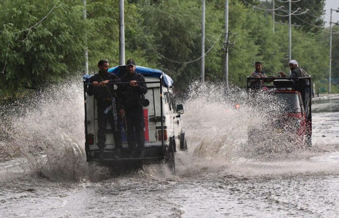 SRINAGAR (India), 19/07/2026.- Personas viajan con sus vehículos durante las inundaciones en Srinagar, Cachemira, India, 19 July 2026. EFE/EPA/FAROOQ KHAN
