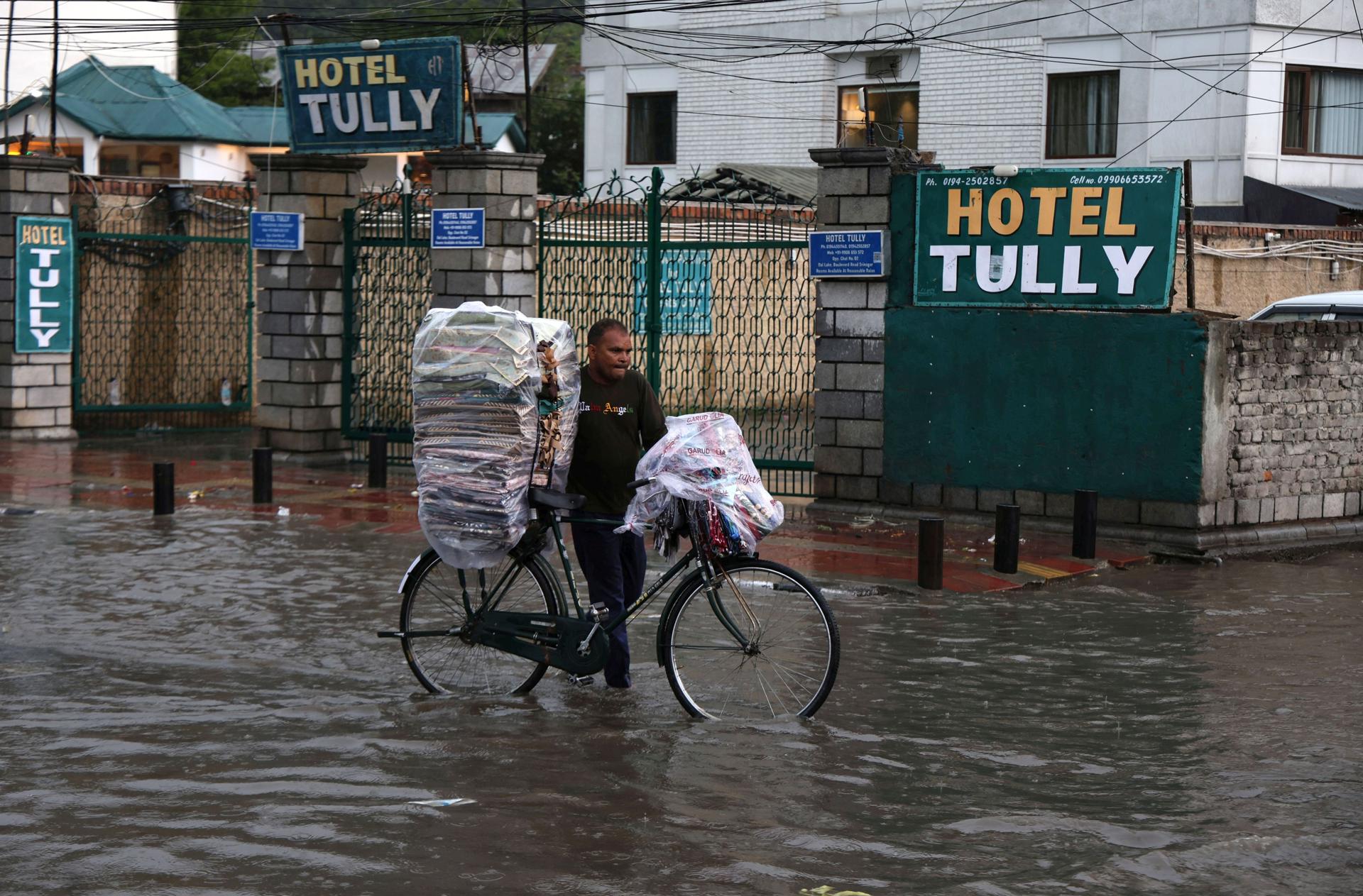 SRINAGAR (India), 19/07/2026.- Un hombre empuja una bicicleta durante las inundaciones en Srinagar, Cachemira, India. EFE/EPA/FAROOQ KHAN