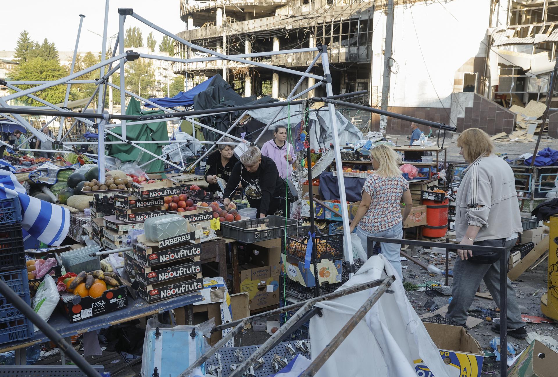 Kiev (Ucrania), 19/07/2026.- Residentes limpian y recogen la comida de un mercado afectado por un ataque con misiles rusos en Kiev.
EFE/EPA/SERGEY DOLZHENKO
