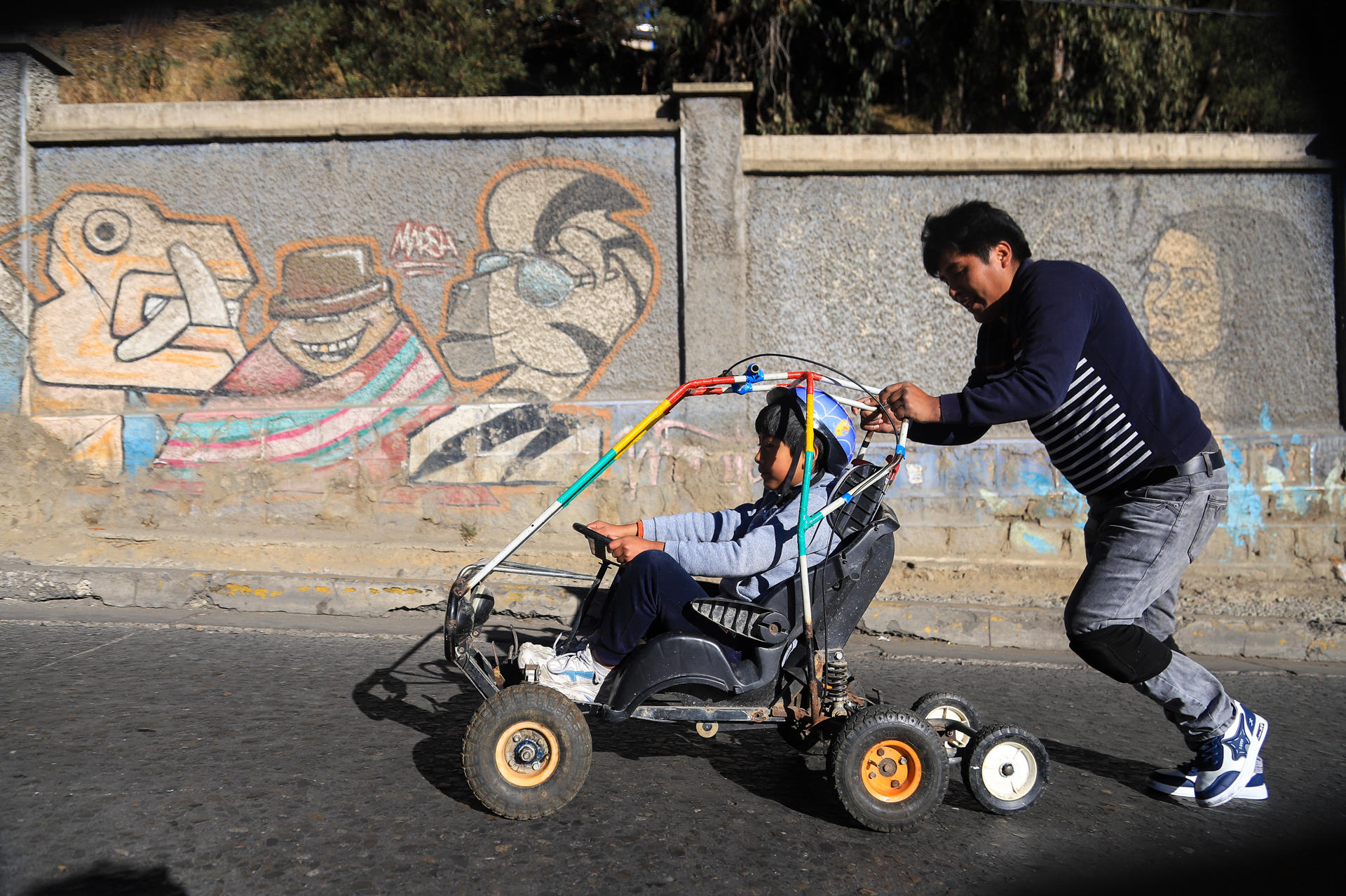 Personas participan en la XXV Carrera de Cochecitos sin Motor una tradición que une a padres e hijos para esta actividad que se realiza este sábado en las empinadas calles de La Paz (Bolivia). EFE/Gabriel Màrquez